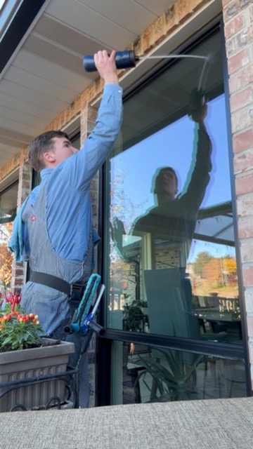 A Seymour's crew member cleaning a home's windows