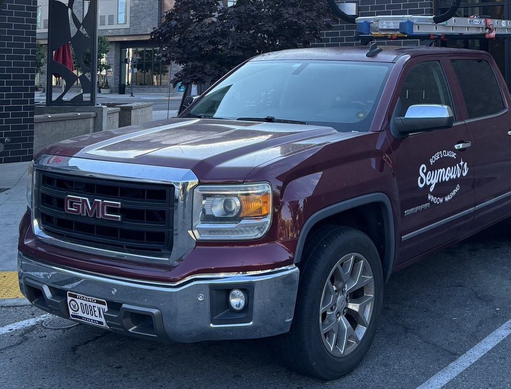 The Seymour's Window Washing truck, ladder racked, parked at a commercial job in Boise