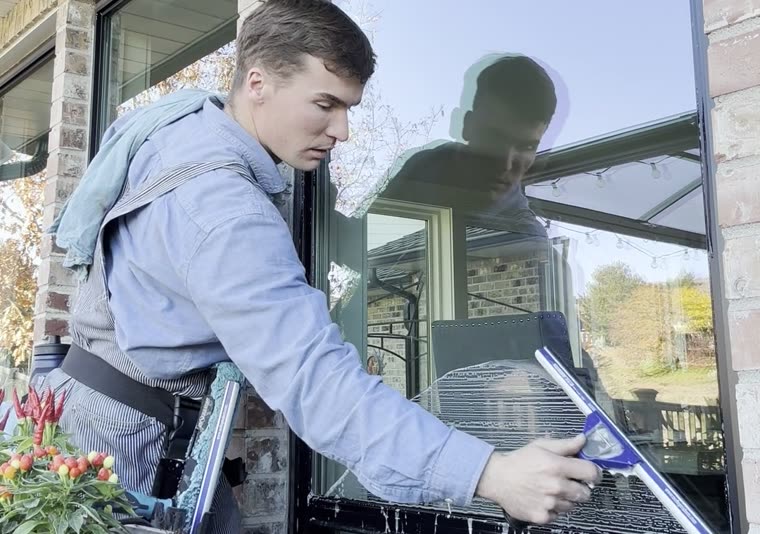A Seymour's technician squeegeeing a ground-floor window at a Boise home