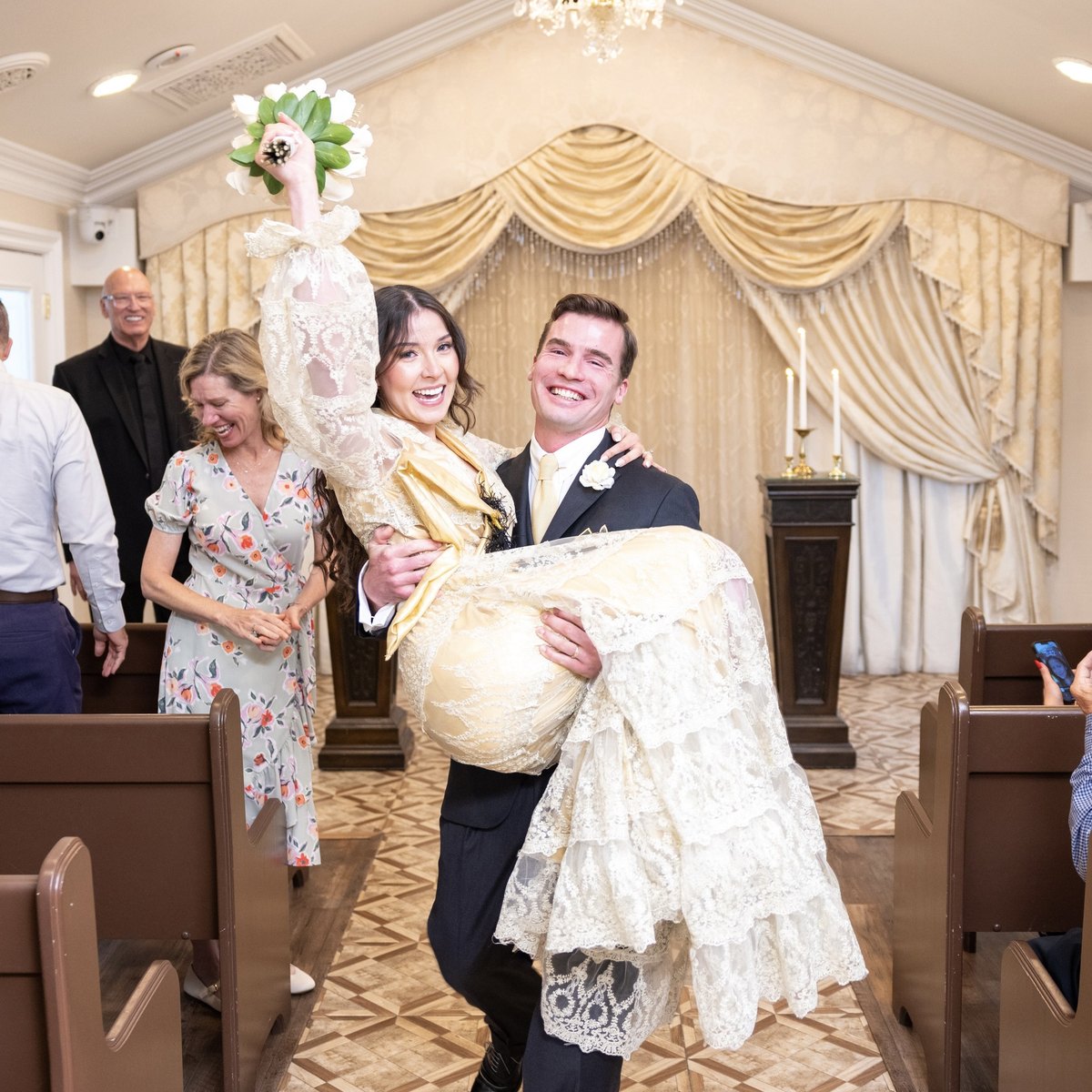 Aaron Seymour carrying his bride down the aisle on their wedding day