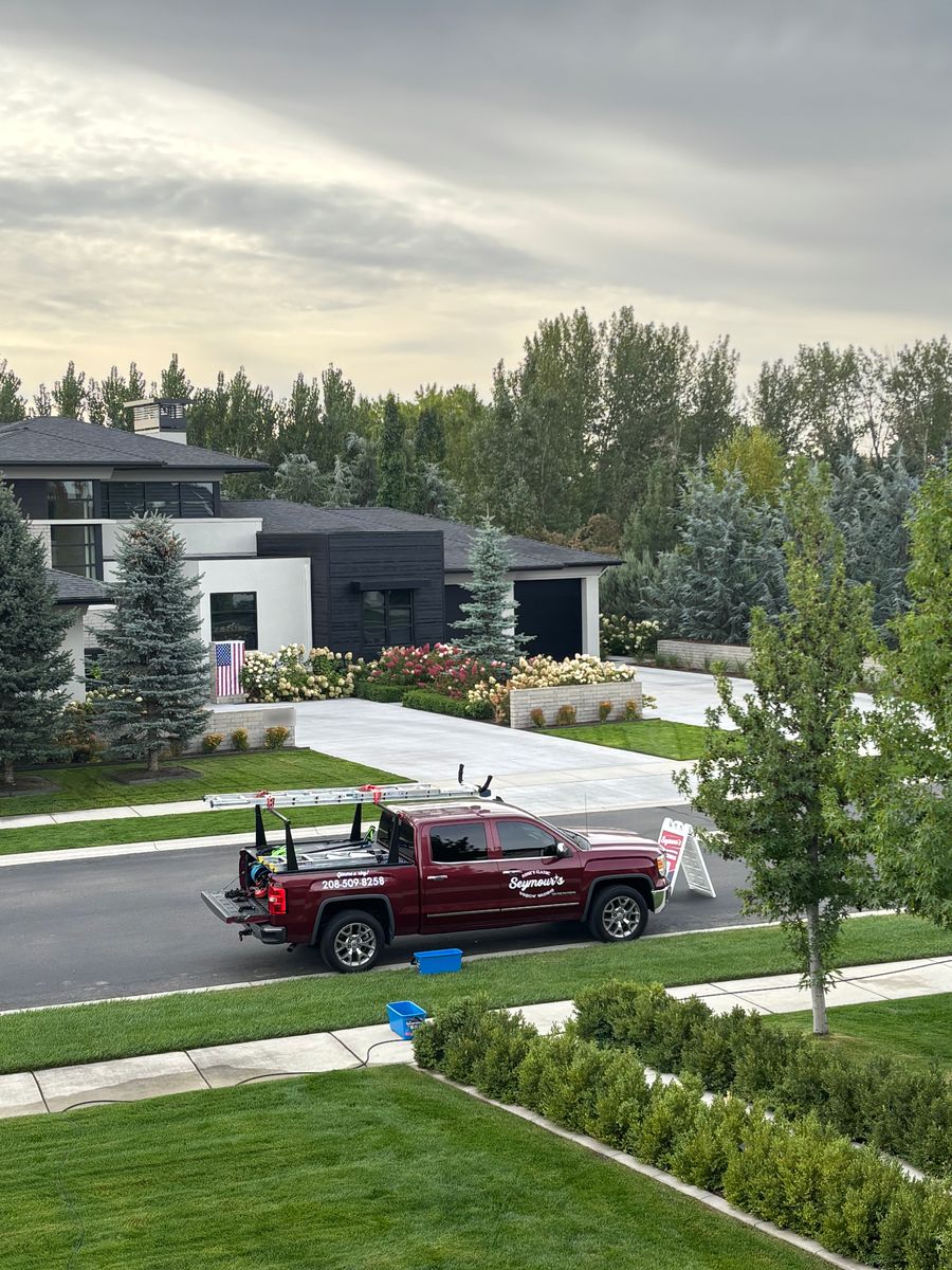 The Seymour's truck, ladders racked, outside a modern Eagle home