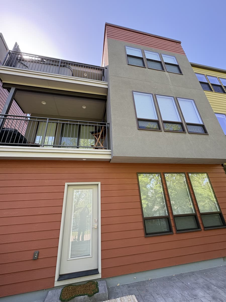 A modern multi-story townhome in Garden City with banks of windows on every floor