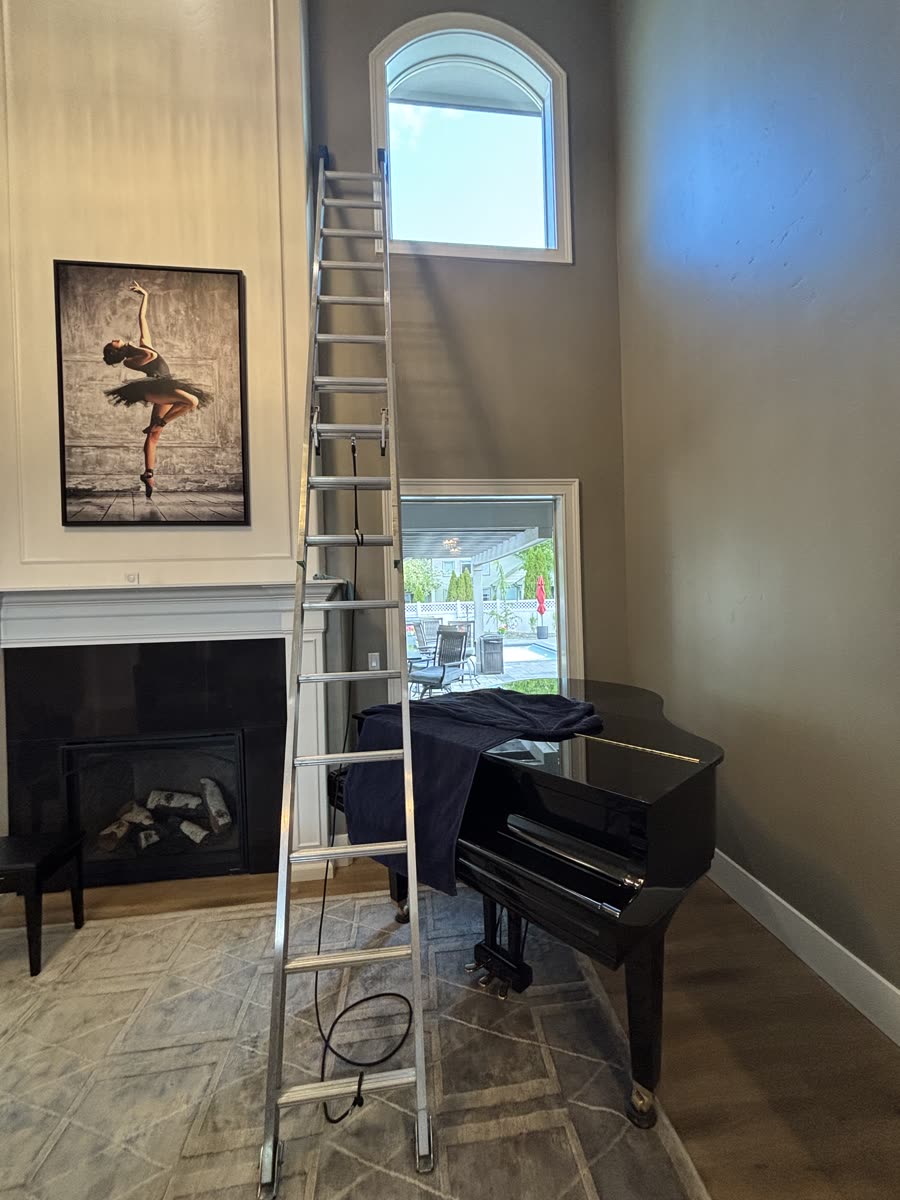 A ladder set up inside a Meridian home to reach a tall upper window