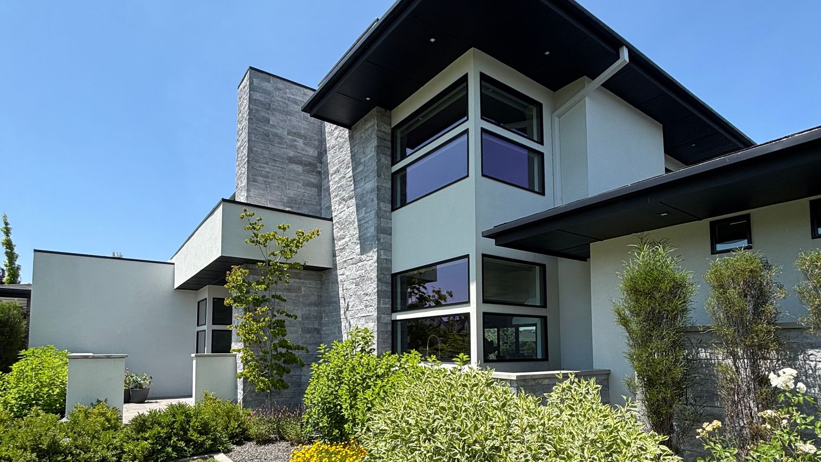 A modern Eagle home with tall corner windows and a planted front yard